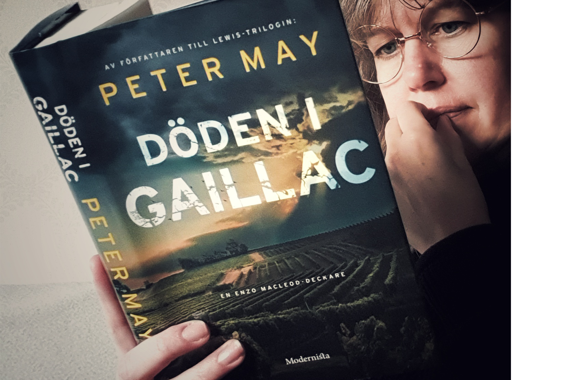 Kvinna med glasögon läser boken Döden i Gaillac av Peter May